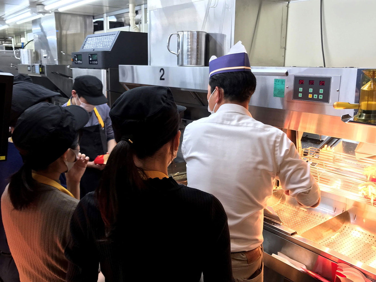 テストキッチンで商品の作り方を聞く学生