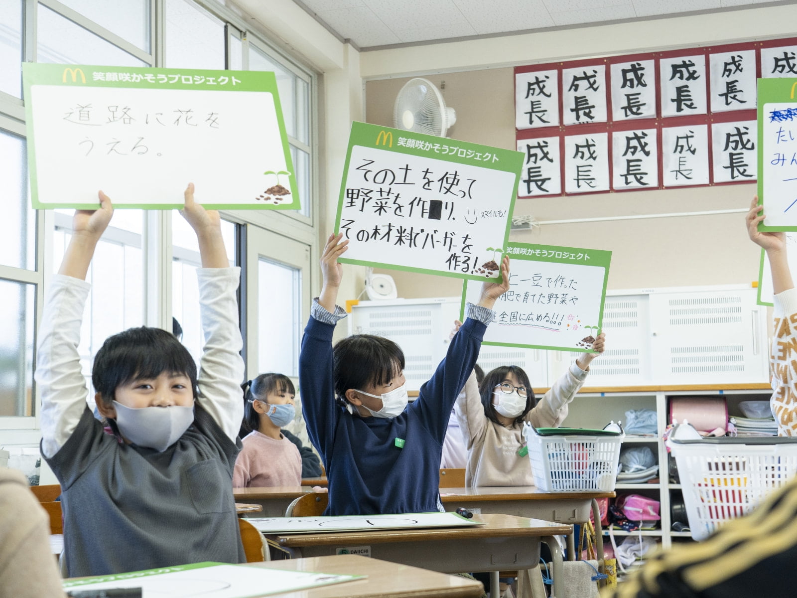 コーヒー豆かすのたい肥を使って何ができるのか発表する児童たち